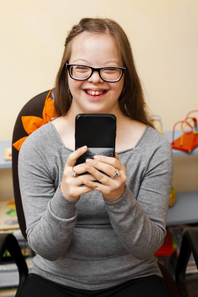 Niña con síndrome down utilizando un teléfono móvil